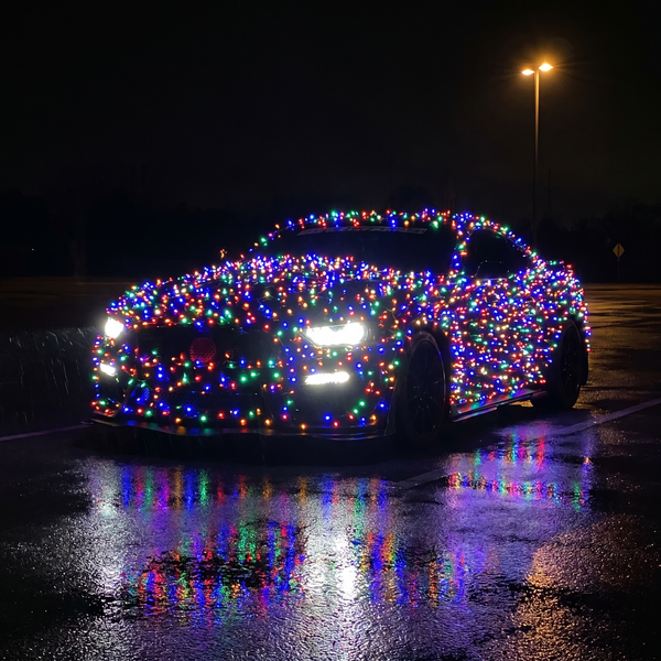 BMW M3 Competition wrapped in JollyRide Christmas lights at night car meet